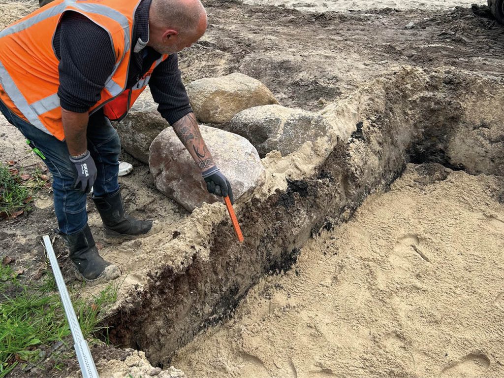 Afbeelding van een gat in de grond wat wordt opgemeten